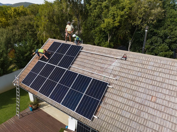 People installing rooftop solar panels. 