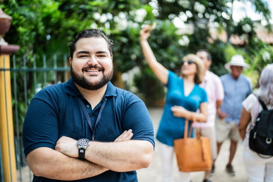 Someone with arms folded is smiling toward the camera.