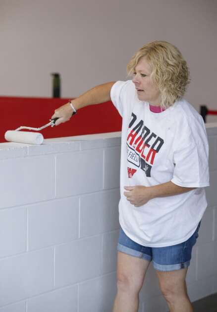 Paraeducator Jodi Bacon paints a low wall Tuesday overlooking the 1,700-seat gymnasium at Williamsburg Junior/Senior High School in Williamsburg. The Williamsburg Community School District is taking a $22.3 million school bond referendum to voters this November that would provide funds for an addition to its elementary school and make site improvements to the junior/senior high school building. The district also would use funds from an existing statewide sales tax to fund some of the improvements. (Jim Slosiarek/The Gazette)