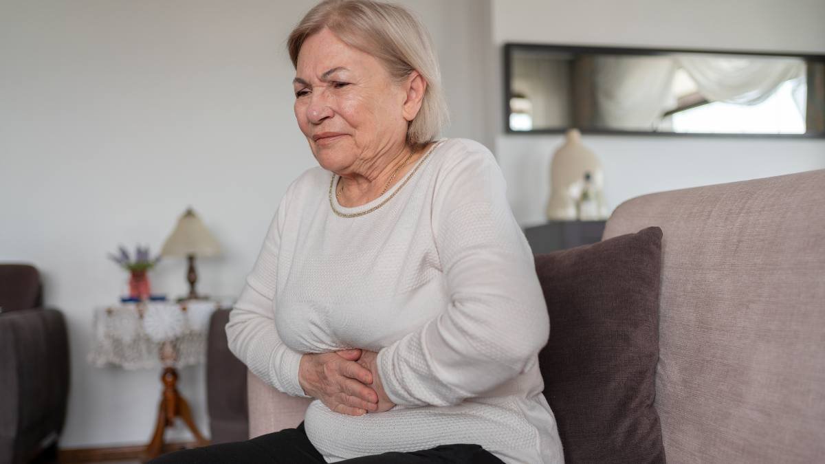 Woman holding her stomach in pain due to bloating