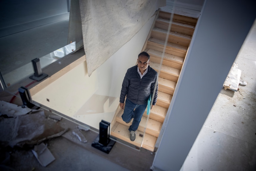 Surya Kant stands on a staircase in a home that is still under construction.