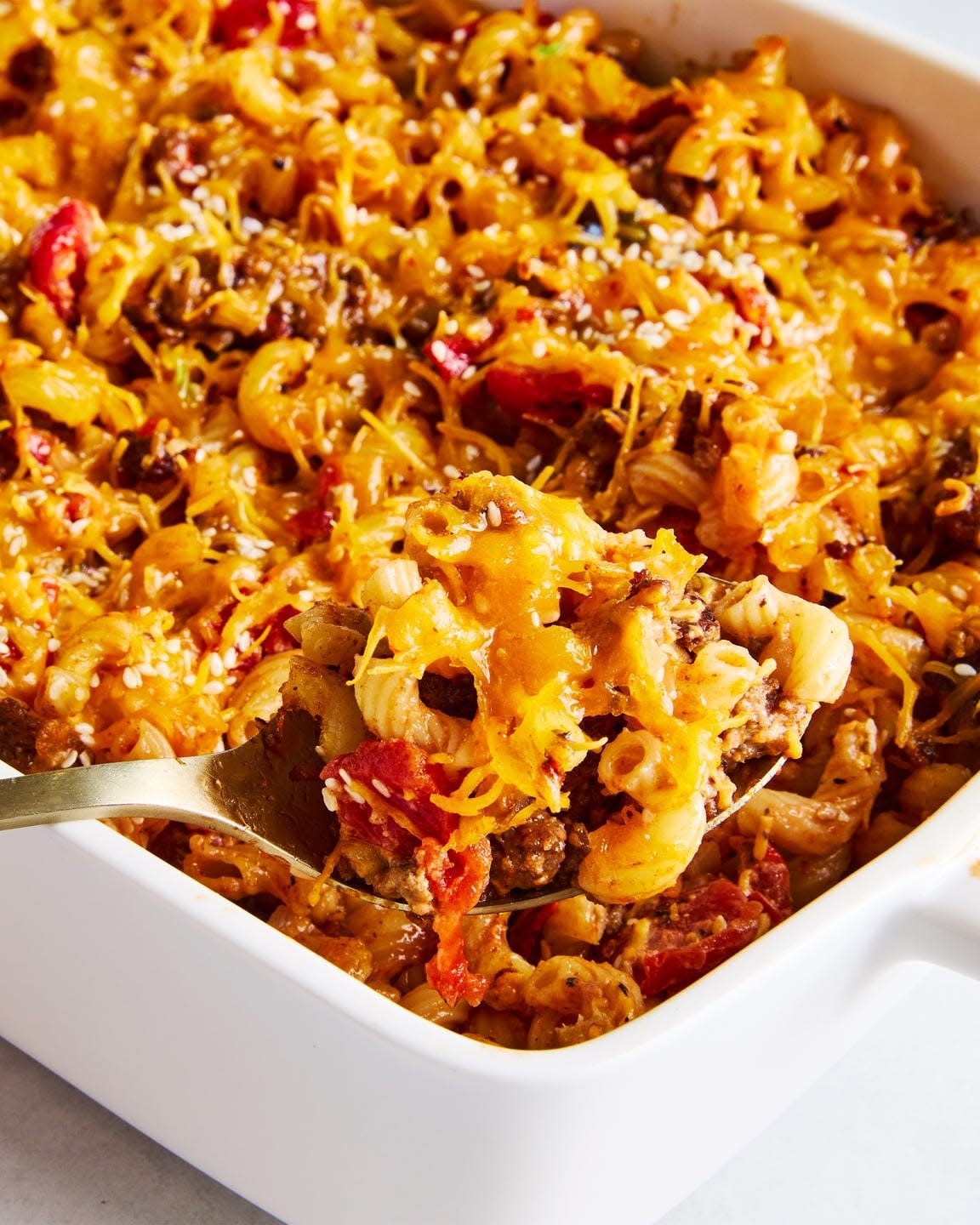 a casserole dish filled with elbow macaroni, ground beef, and a creamy sauce