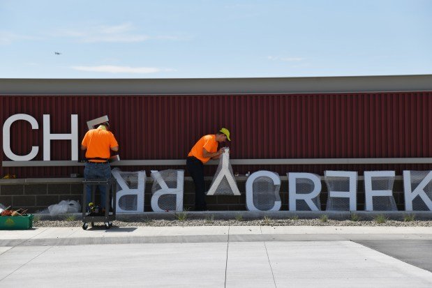 Alan Borden, left, and Jamie Williams of Fastsign DTC install a sign outside of the Cherry Creek Innovation Campus on Tuesday, July 30, 2019. The 117,000-square-foot facility located east of Dove Valley Regional Park will serve as a unique resource for 11th and 12th-grade students across the district. (Photo by Hyoung Chang/The Denver Post)