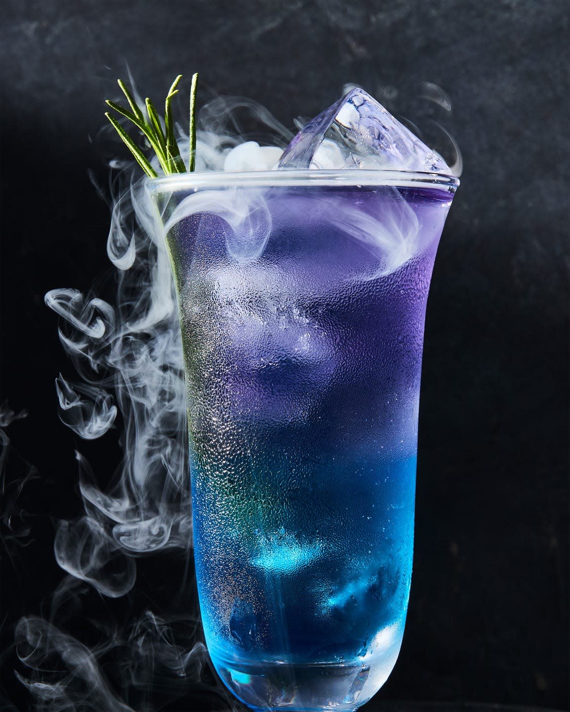 purple and blue layered drink with rosemary