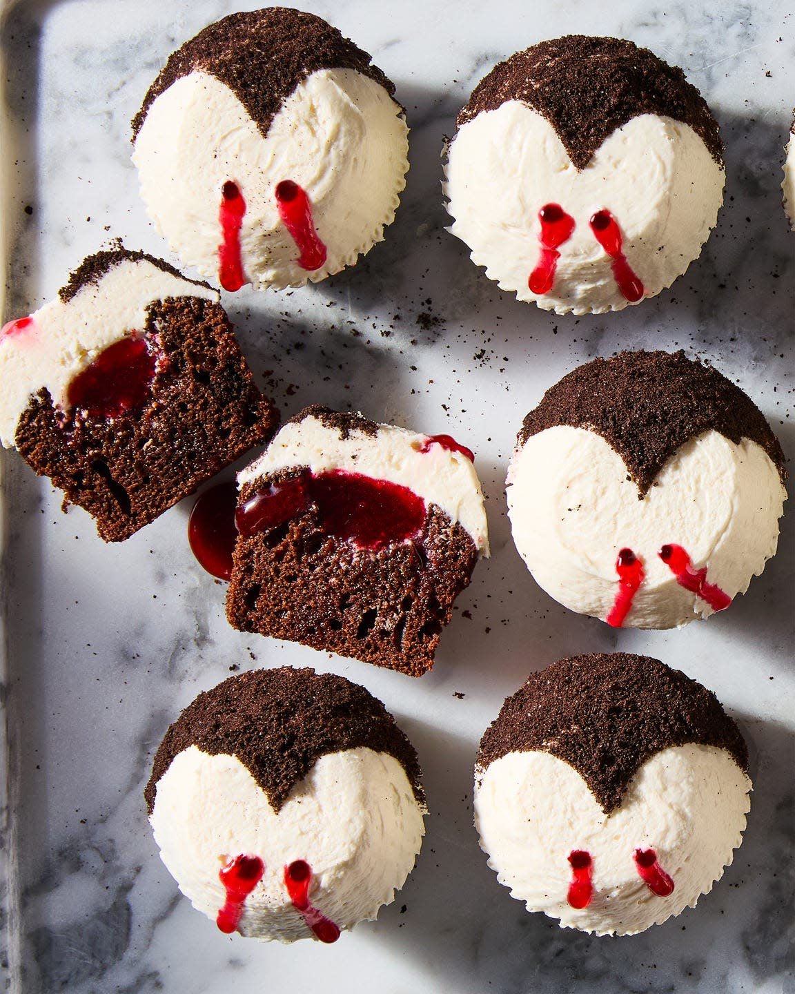 chocolate cupcakes topped with white icing and red lines