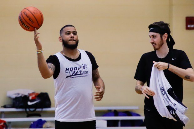 A Hoops for HOPE participant spins a basketball on his...