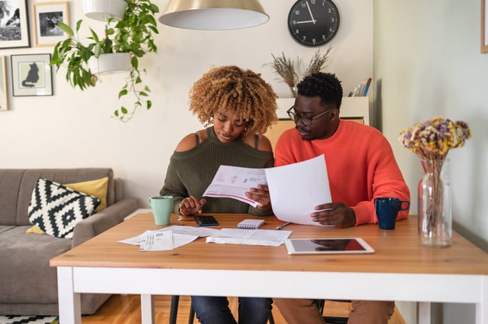 Two people sitting at a table looking at documents.