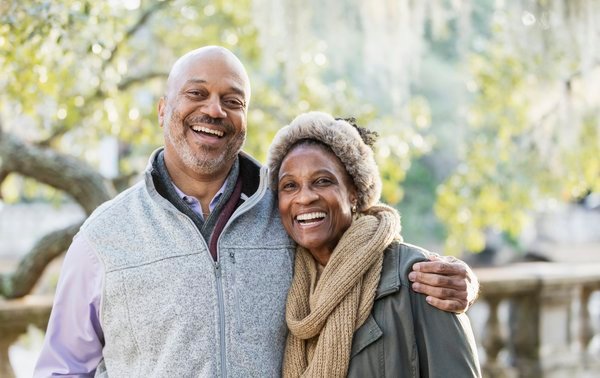 Two people smiling together outside.