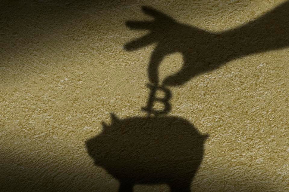 The shadow of hand putting a coin into piggy bank.