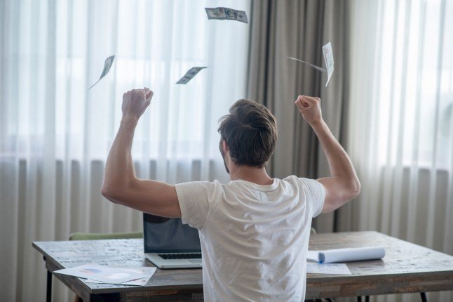 A man sitting at the laptop and feeling happy after a good deal