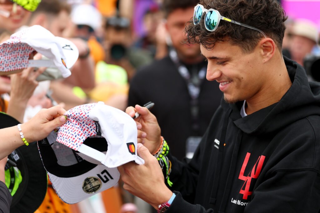Lando Norris of Great Britain and McLaren signs autographs