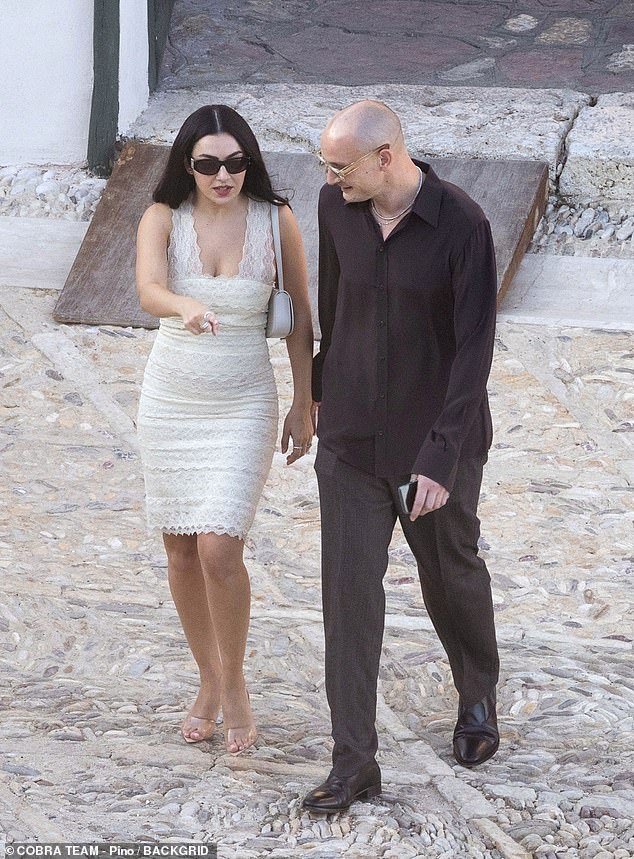 Charli teamed the chic number with a pair of clear heels, added a white shoulder bag and sunglasses