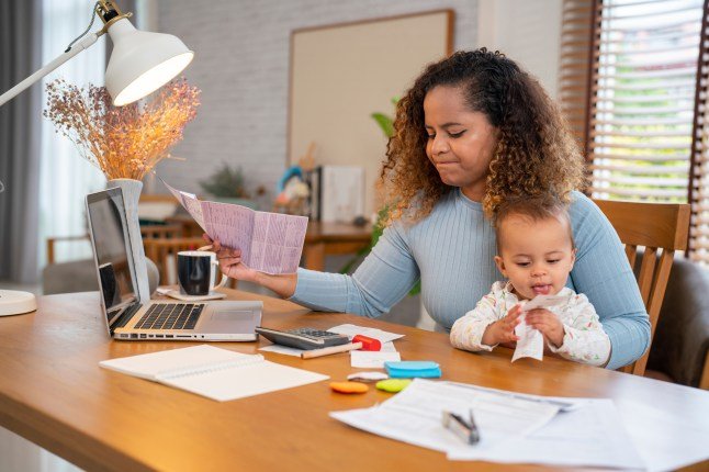 Woman holding paper various expense bills and plans for personal finances at her home.