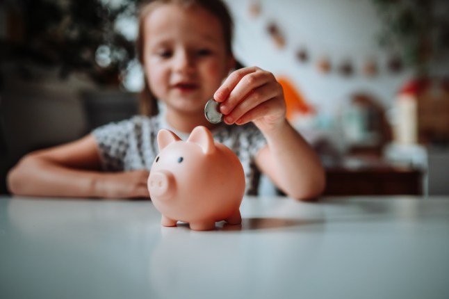 Future Finance: Girl Child Taking the First Steps in Financial Responsibility, Saving in the Piggy Bank.