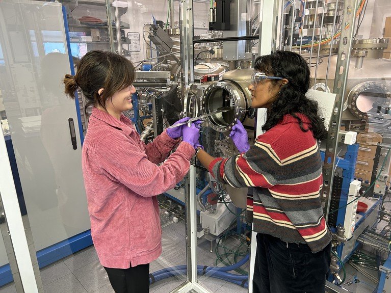 Two graduate students synthesize oxide quantum materials using Molecular Beam Epitaxy in a physics lab.