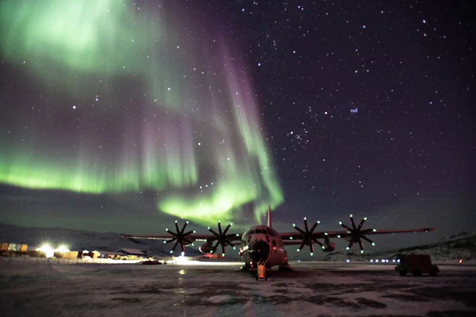 A LC-130 Skibird from the 109th Airlift Wing sits on the ramp at Kangerlussuaq Airport, Greenland with the Northern Lights dazzling in the sky above. The Northern Lights occur during the winter and are especially bright on a dark night in Greenland. The 109th conducts training and scientific research support annually from March-August. Photo Courtesy of Lt. Col. Kevin Jones