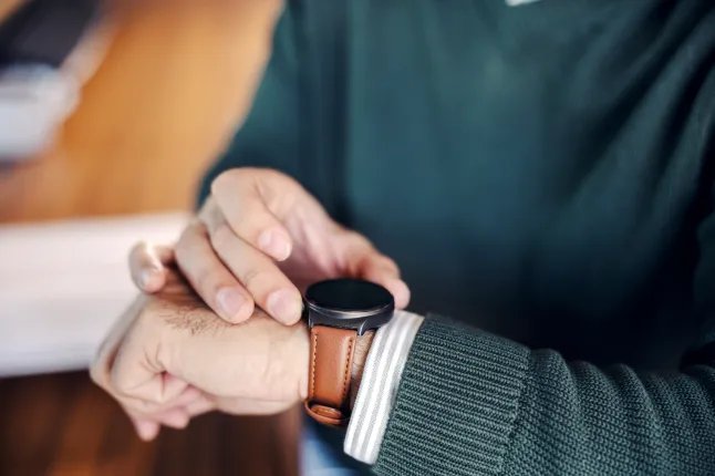 Man tapping smartwatch checking time and notifications