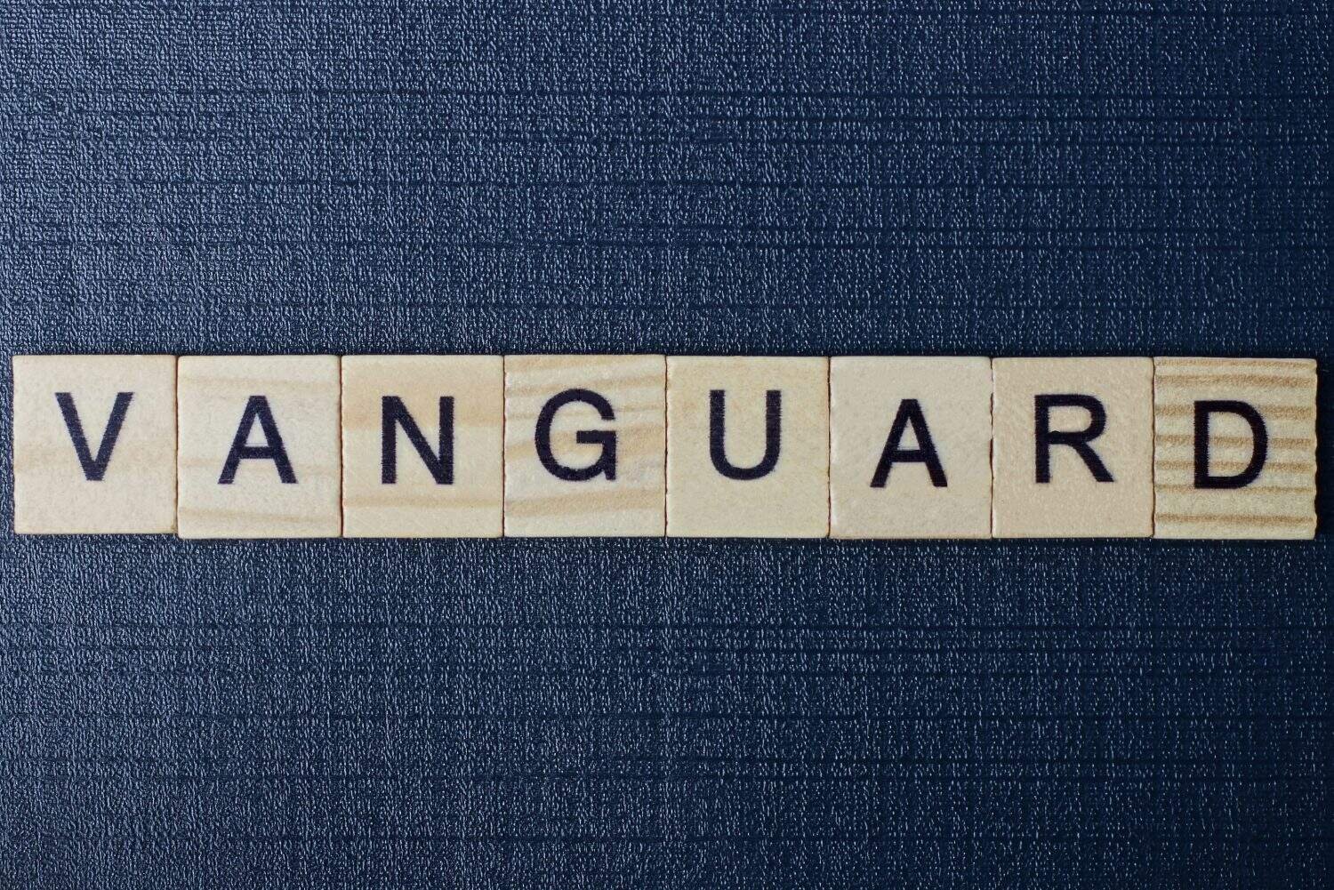 text on word vanguard from gray wooden letters on a black background