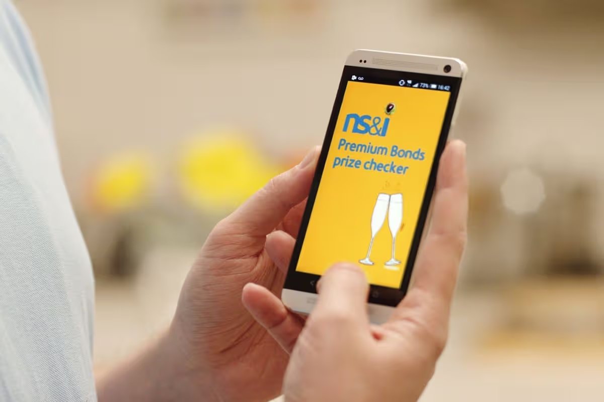 NS&I winner holding their phone in both hands