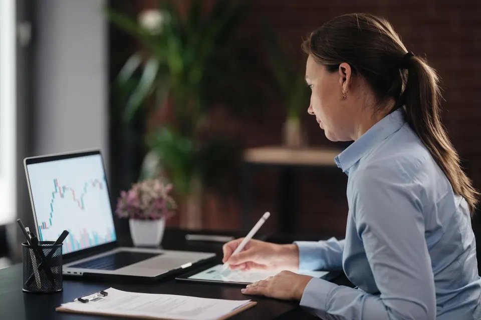 A woman taking investment notes such as learning how to buy an ETF.