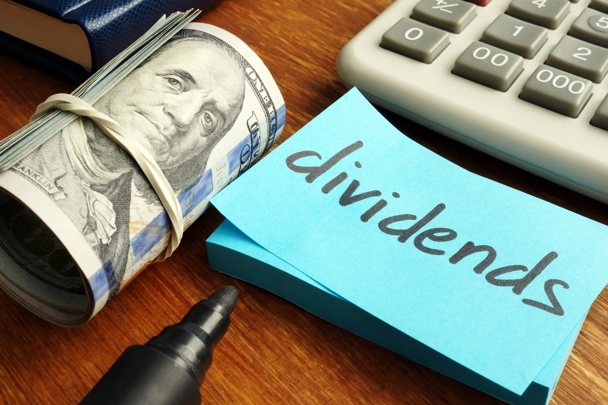 Rolled up dollar bills with a post-it saying "dividends."
