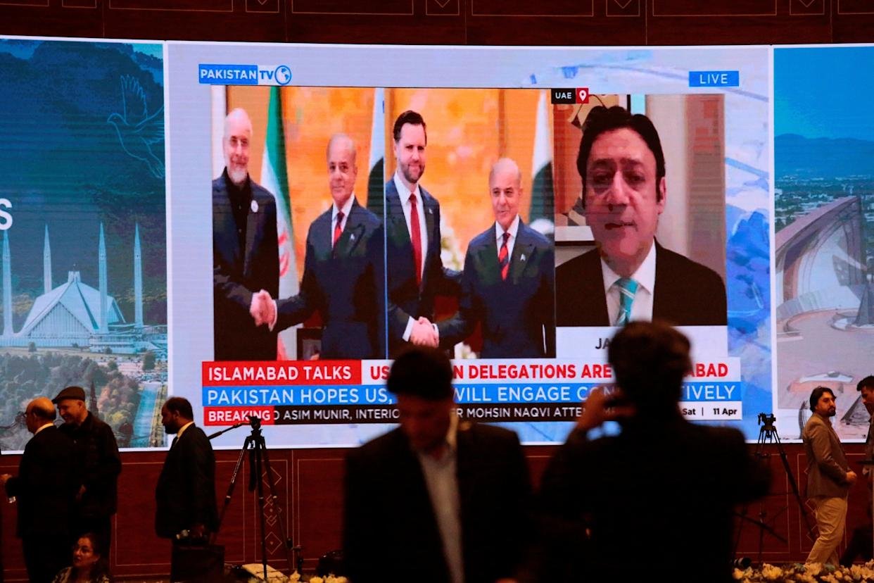 Members of the media work as a screen displays news with images of Pakistan's Prime Minister Shehbaz Sharif meeting with U.S. Vice President JD Vance and separately with Iranian Parliament Speaker Mohammad Bagher Ghalibaf, at a media centre set up for the coverage of the U.S.-Iran peace talks in Islamabad, Pakistan, April 11, 2026.