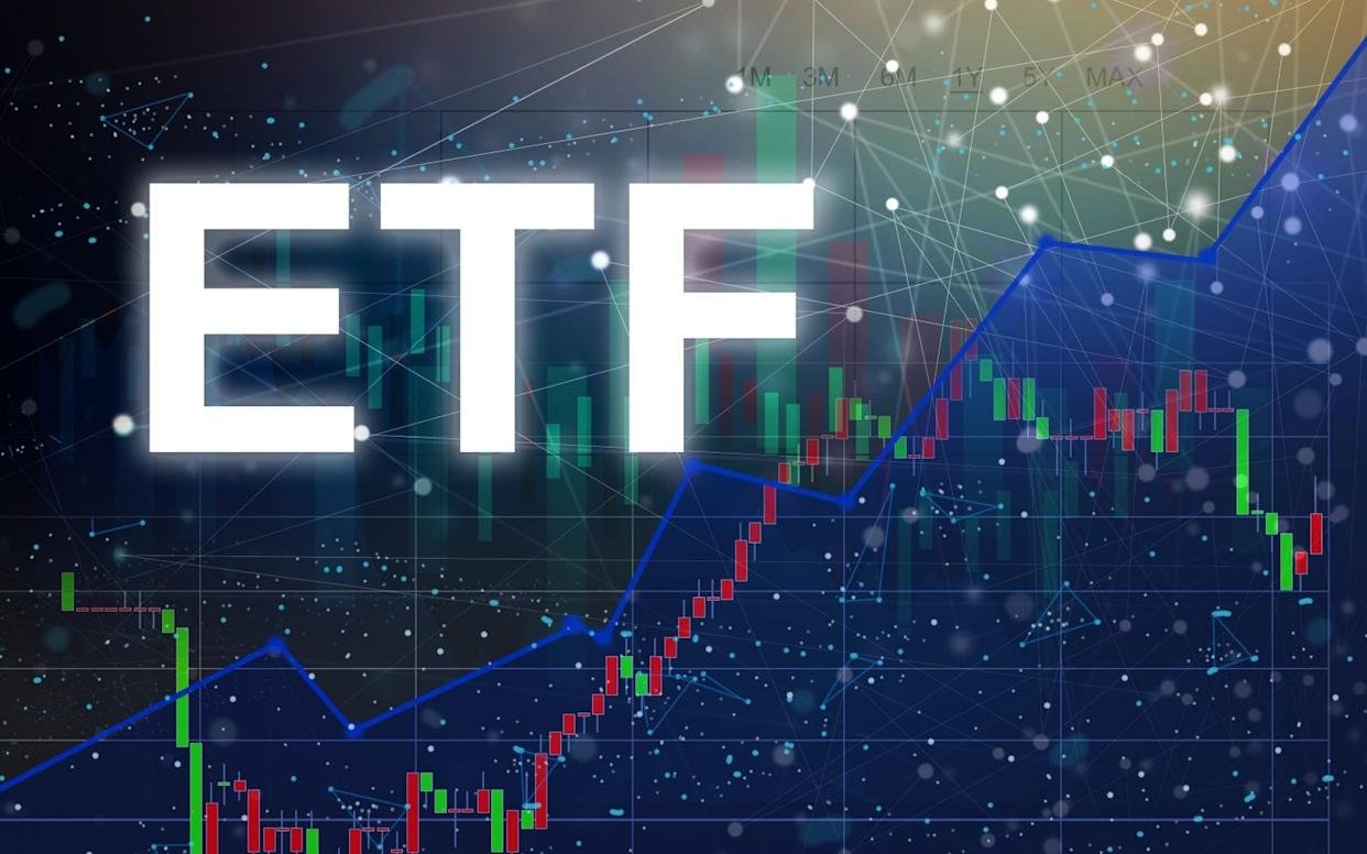 The letters 'ETF' in large, glowing white font are centered against a dark blue background. Behind the text are various financial charts, including red and green candlestick patterns representing market fluctuations, and a prominent blue line graph showing an upward trend. A subtle digital network grid with connected dots overlays the entire background, suggesting connectivity and data. The overall mood is analytical and forward-looking, related to financial investing.