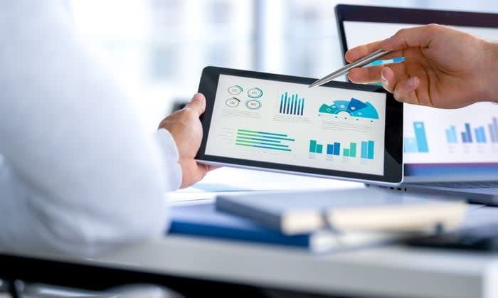 People looking at financial statements on a tablet.