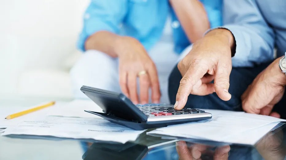 Closeup of a senior man's hand calculating bills at home