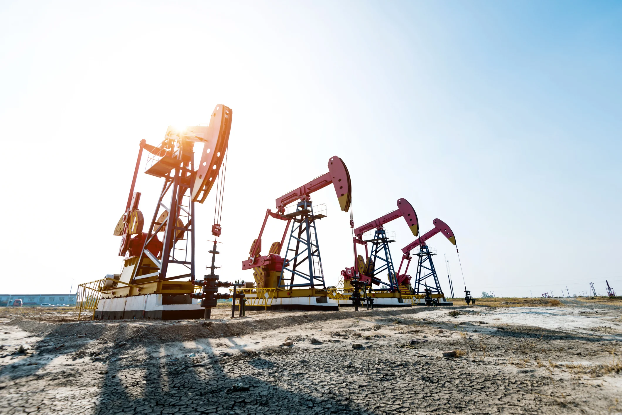 Three oil derricks in the desert.