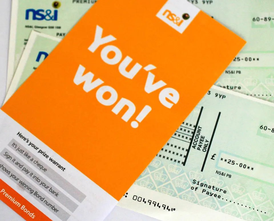 British Premium Bond prize warrant and cheque for 25 pounds, with "You've won!" written on the warrant.