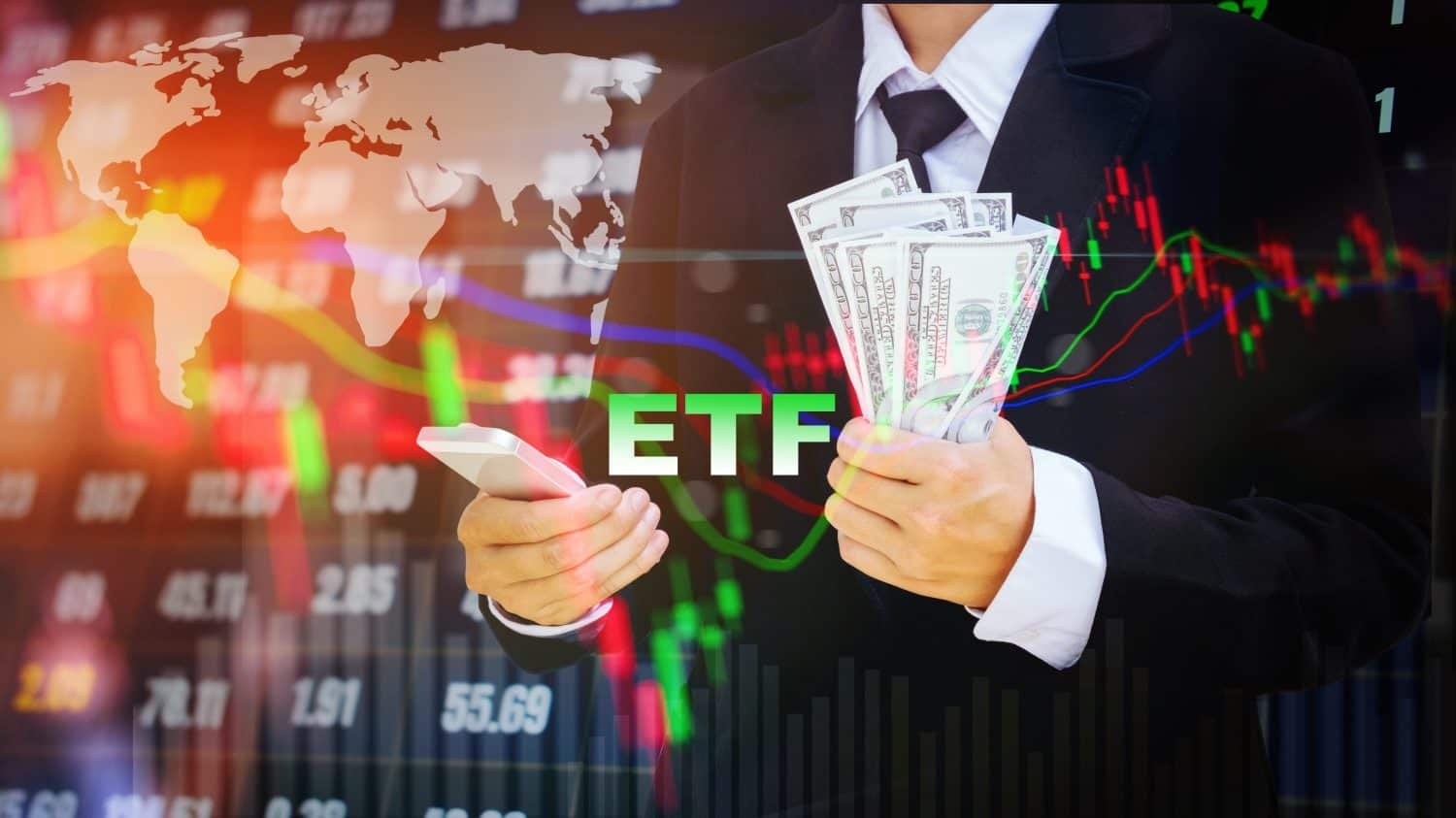 A person in a suit holds a white smartphone in their left hand and a fan of US dollar bills in their right, with the word 'ETF' in bright green text prominently displayed in the center foreground. The background features a blurred, glowing digital display of stock market candlestick charts, line graphs, numerical data, and a translucent white world map.
