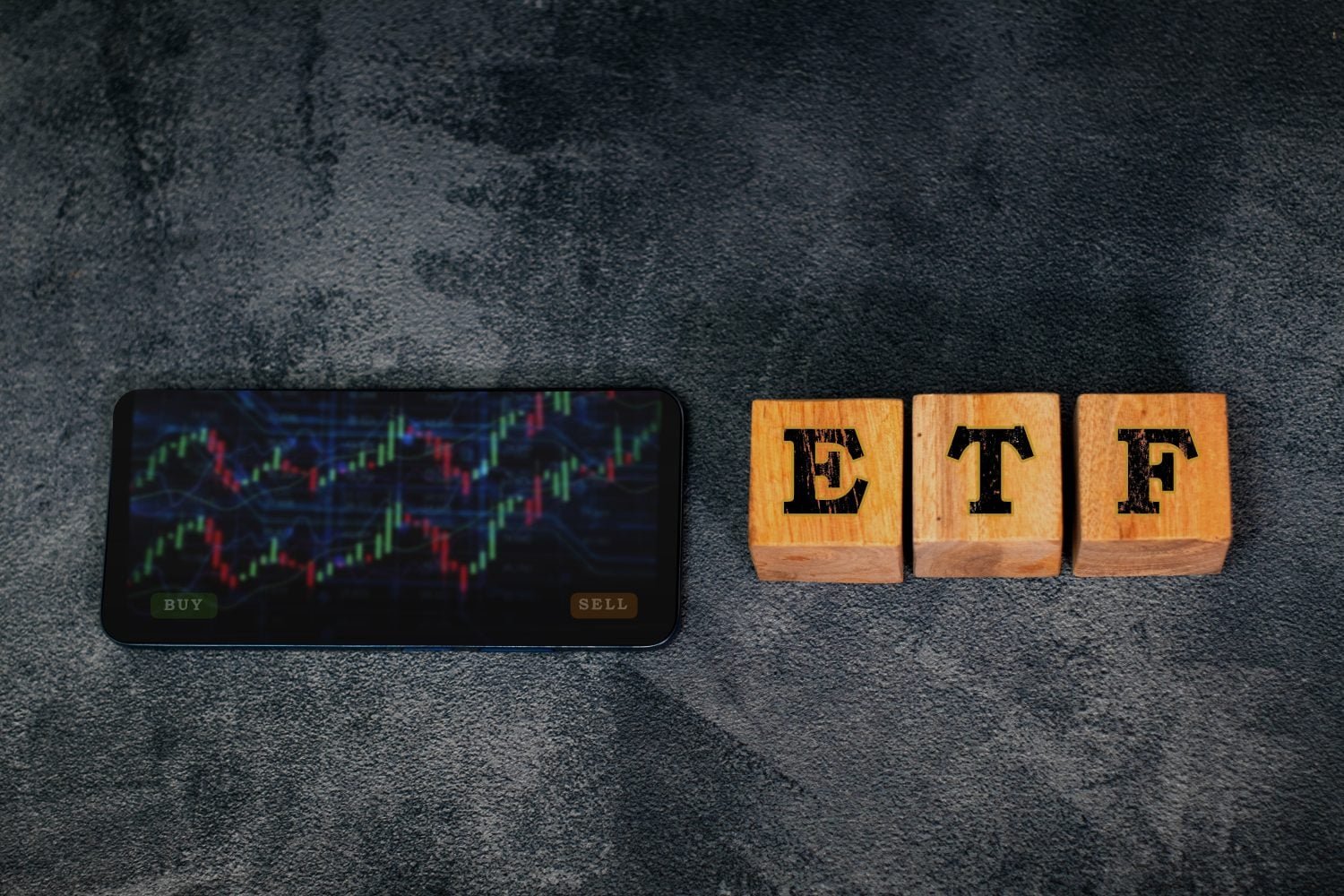 Wooden blocks spelling “ETH” placed beside a smartphone displaying a colorful crypto chart, representing ethereum trading, blockchain technology, and digital asset market trends in modern finance.