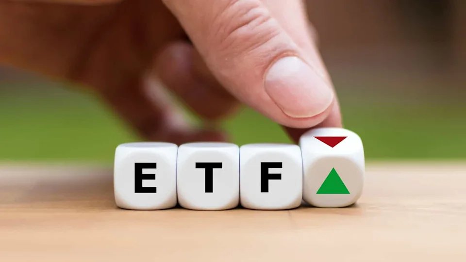 Hand is turning a dice and changes the direction of an arrow symbolizing that the value of an ETF (Exchange Traded Fund) is going up (or vice versa)