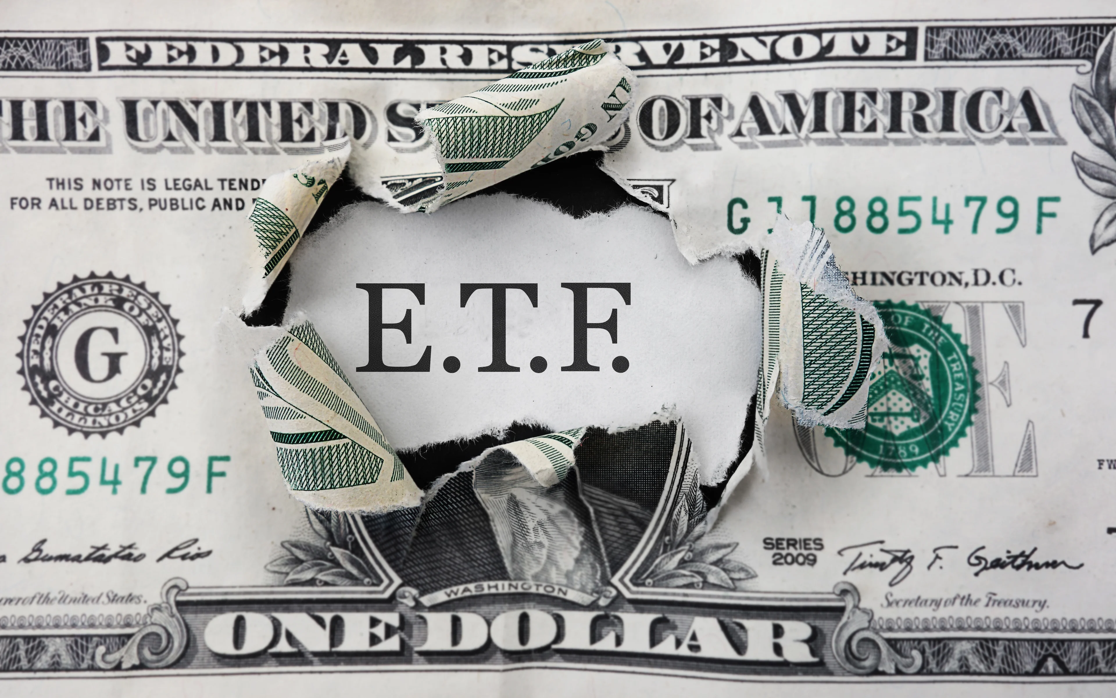 A dollar bill with a hole in the middle and the letters ETF.