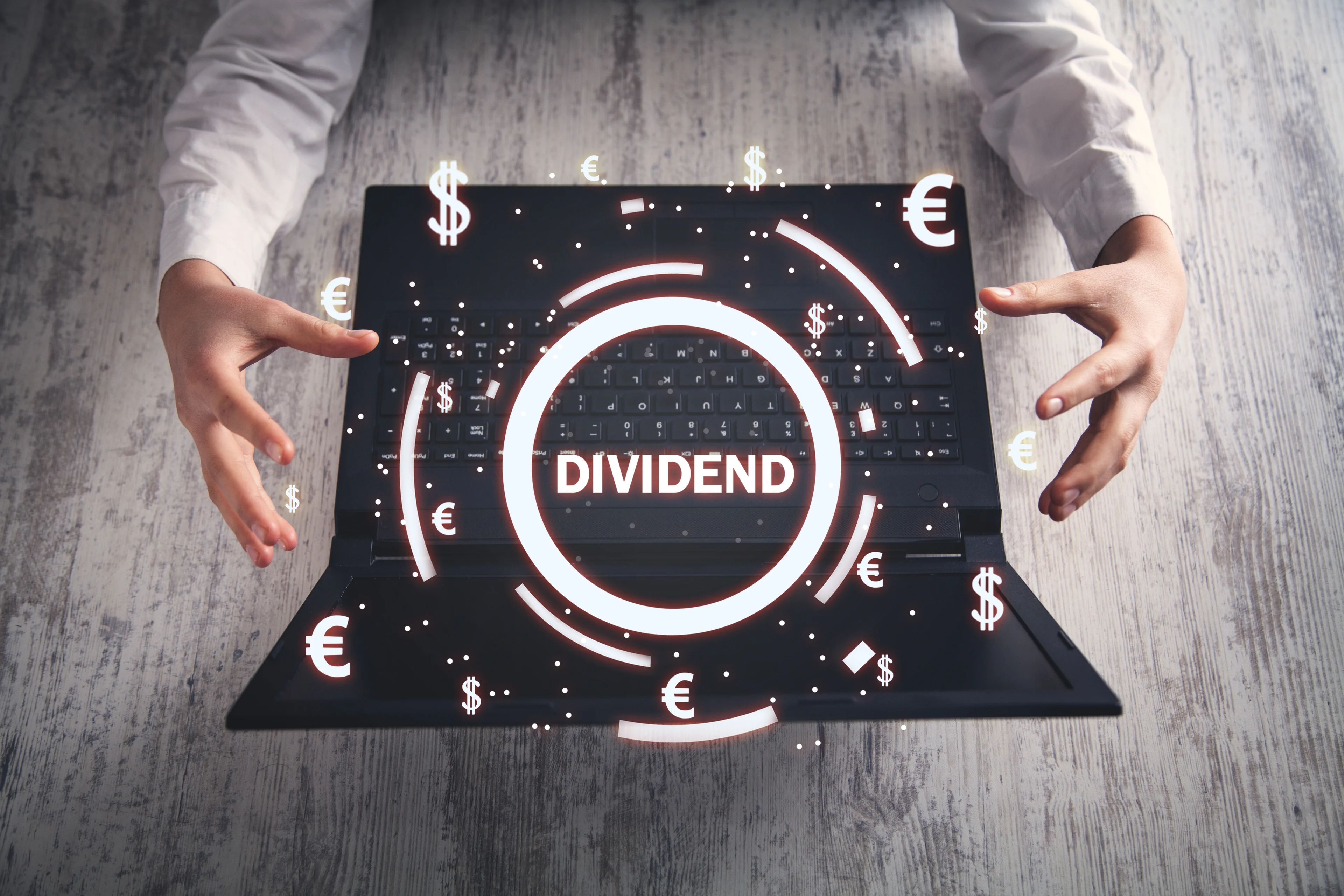 The word dividend hovering above a laptop.