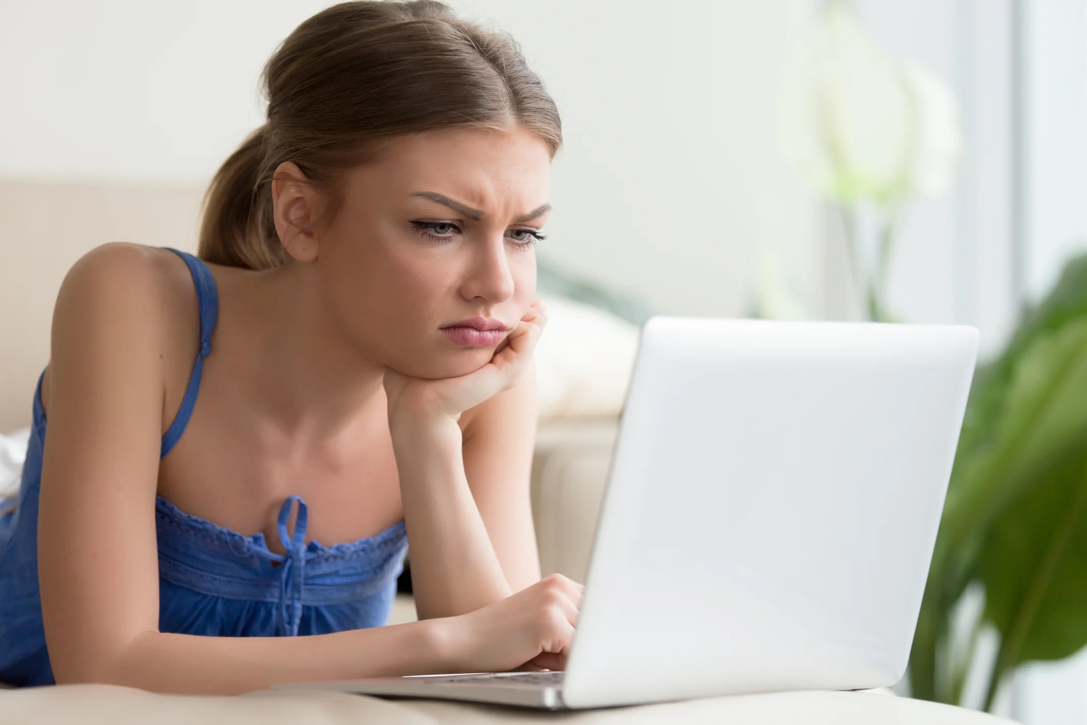 A frustrated person looking at a laptop computer.