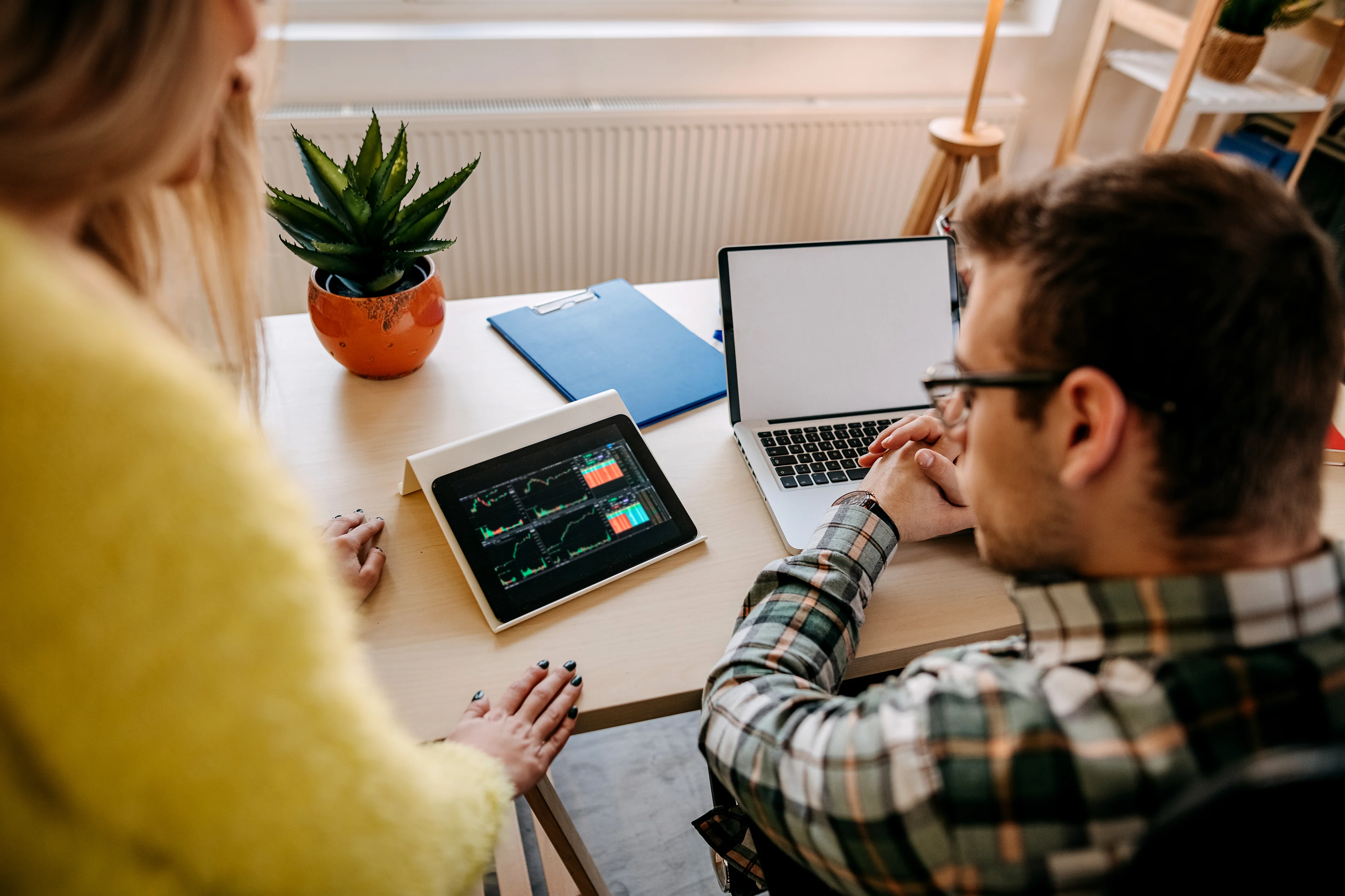 A couple reviewing financial statements on a tablet.